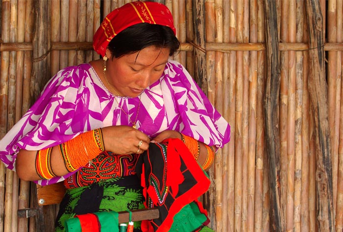 mujer guna tejiendo una mola
